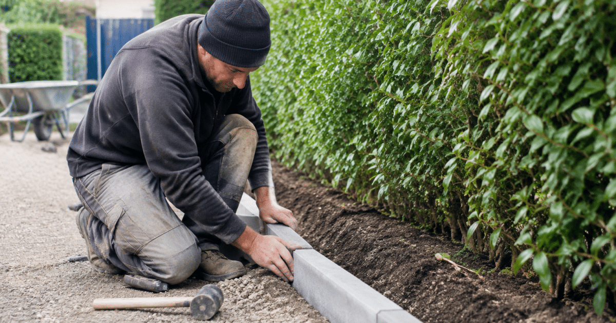Ouvrier installer bordure beton grise le long allee jardin
