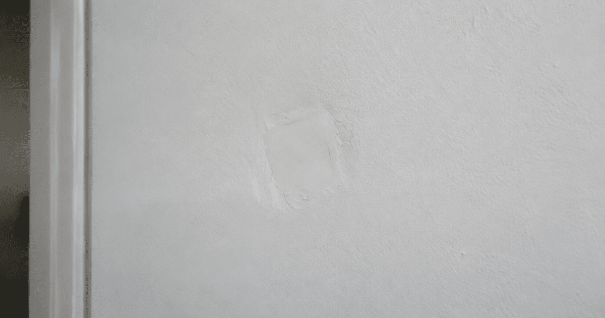 Mur blanc avec trou rempli de pate de joint lisse