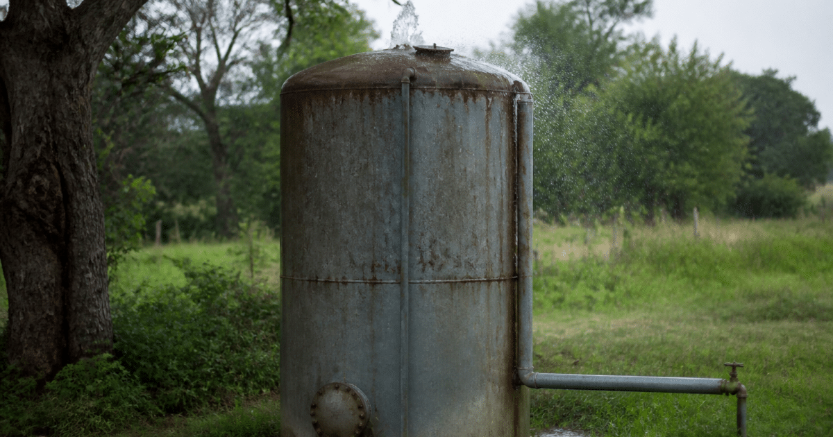 Reservoir metallique vertical avec eau s'echappant du sommet