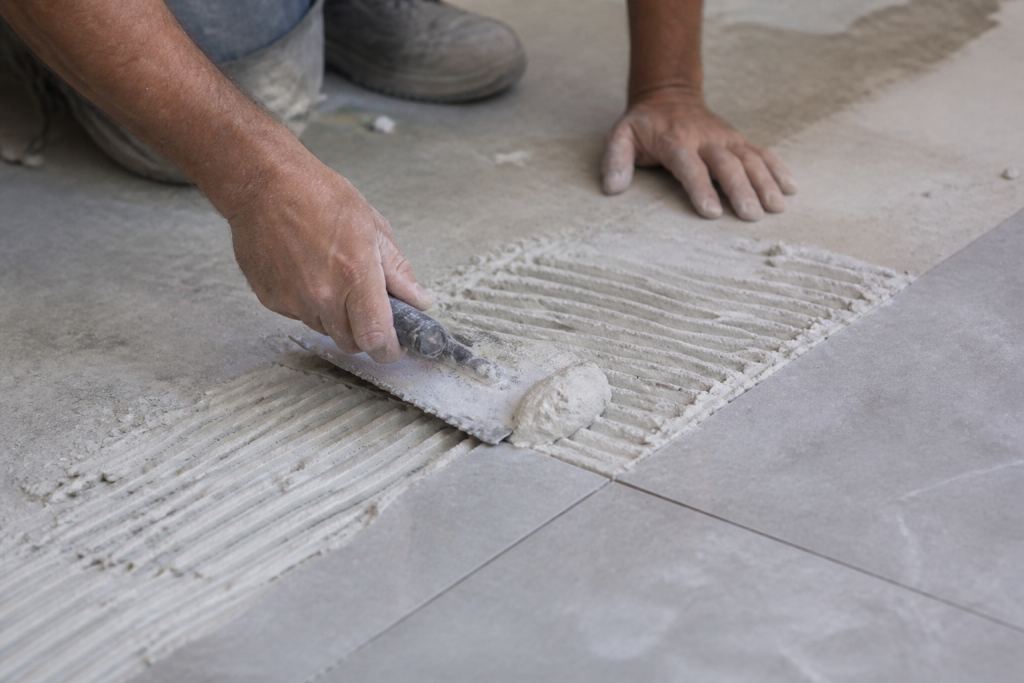 Truelle etalant mortier blanc sur carreaux