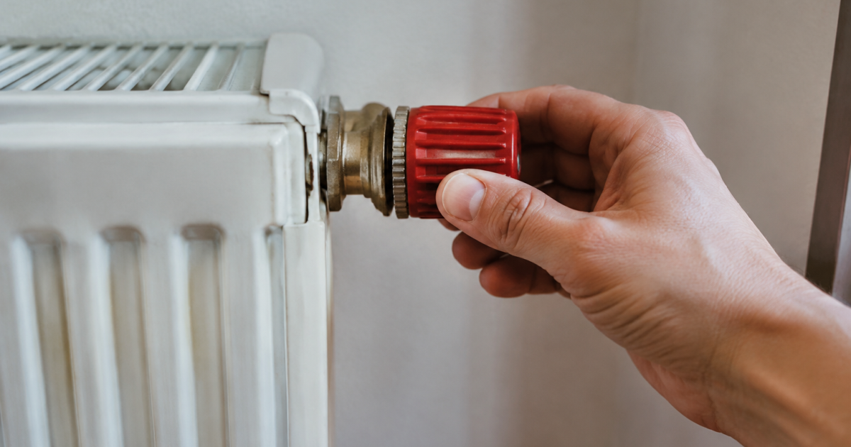 Mains retirant valve rouge du radiateur blanc
